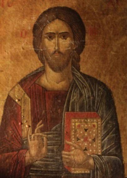 Byzantine icon painting of Jesus Christ Pantocrator holding a decorated gospel book and raising his right hand in a gesture of blessing.